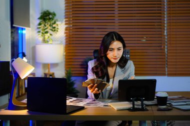 Kadın mimar malzemeleri seçiyor. Örnekleri bitirerek karşılaştırıyor. Kadın iç mimari, kumaş spektrumlu yenileme malzemeleri seçiyor..