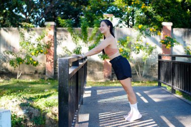 Spor eğitimi için ısınırken esneme hareketleri yapan mutlu bayan sporcu..