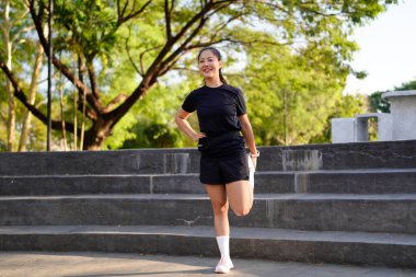 Spor eğitimi için ısınırken esneme hareketleri yapan mutlu bayan sporcu..