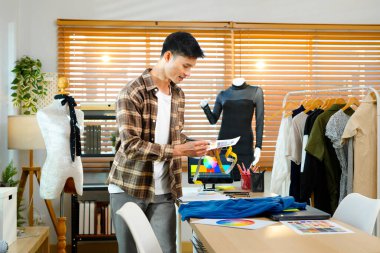 Moda tasarımcısı olarak çalışan erkekler, iş yerindeki kıyafet için renk çizelgesi seçiyorlar..