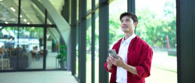 Ofis arka planında akıllı telefon kullanan işadamı ve kopyalama alanı.