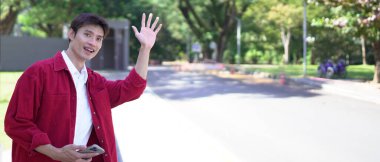 Akıllı telefonu olan Asyalı bir adam arkadaşlarıyla buluşur ya da akşam sokakta taksi çağırır..