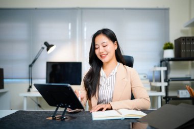 Ofisteki dijital tablette çalışan iş kadını.