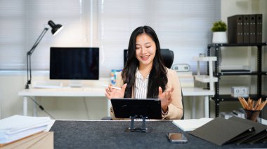 İşyerindeki müşteriyle tablet çalışma videosu konferansı kullanan serbest çalışan iş kadınları.