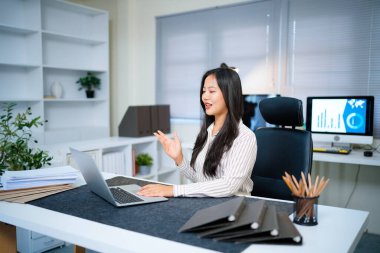 Asyalı kadın bilgisayarlı video konferans konferansını ofis işyerine götürüyor...
