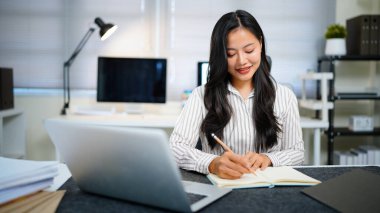 Ofiste iş kadınlarıyla yazma, planlama ve bilgisayar denetim sonuçları ve ekonomi grafiği. Bütçe incelemesi için acentedeki kişi ile vergi teslim tarihi, hesap yöneticisi ve dijital rapor.