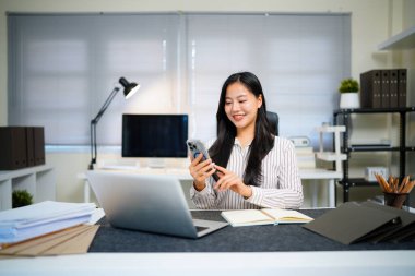 Voice note, chatting or talking of a woman on the phone at work in the office. Businesswoman talking on her speaker sending a voicemail or audio message to a colleague about work plan or schedule..