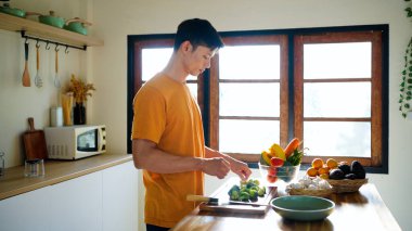 Sağlık, beslenme ya da vejetaryen beslenme için sebze kesme. Erkek insan, bakkaliye ve ahşap tahta mutfak yemek ve malzemelerle ev yemeği hazırlamak için.