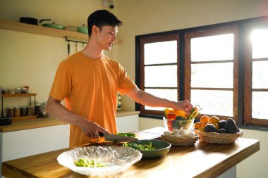 Sağlık, beslenme ya da vejetaryen beslenme için sebze kesme. Erkek insan, bakkaliye ve ahşap tahta mutfak yemek ve malzemelerle ev yemeği hazırlamak için.
