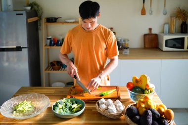 Sağlık, beslenme ya da vejetaryen beslenme için sebze kesme. Erkek insan, bakkaliye ve ahşap tahta mutfak yemek ve malzemelerle ev yemeği hazırlamak için.