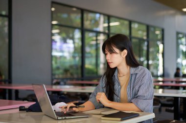Kampüste eğitim, üniversite ve kadın, okul projesi veya sınavı için araştırma ve kitaplar. Laptop, dizüstü bilgisayar ve internet. Üniversite öğrencisi. Kampüste teknoloji ve öğrenim görüyor..