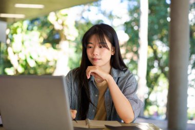 Kampüste eğitim, üniversite ve kadın, okul projesi veya sınavı için araştırma ve kitaplar. Laptop, dizüstü bilgisayar ve internet. Üniversite öğrencisi. Kampüste teknoloji ve öğrenim görüyor..