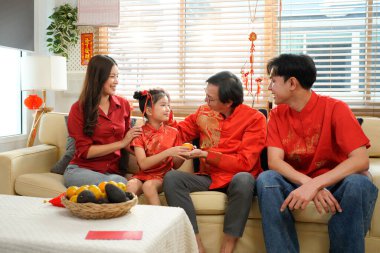 Çin Yeni Yıl kutlamaları sırasında kırmızı zarfları değiş tokuş eden çok nesilli bir aile..