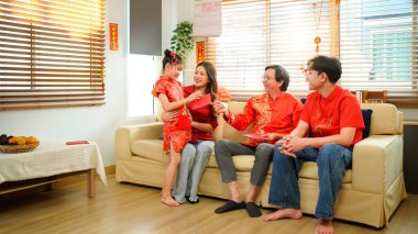 Çin Yeni Yıl kutlamaları sırasında kırmızı zarfları değiş tokuş eden çok nesilli bir aile..