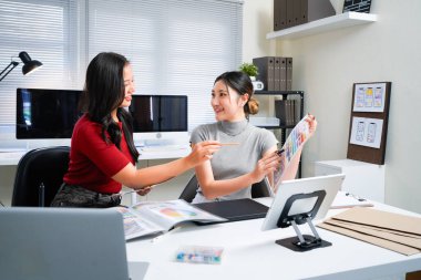 Yaratıcı tasarım projesinde işbirliği yapan iki profesyonel kadın, modern ofis çalışma masasında renkli renk örnekleri, renkler ve paletleri tartışıyorlar. Duvar kağıdı ve poster için ideal..