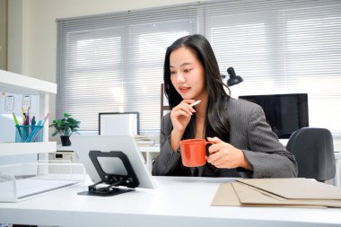 Genç bir kadın iş uygulaması için ped bilgisayar kullanıyor. Modern ofiste çalışmak için CEO 'su iş kadını profesyonel görünümlü dijital tablet bilgisayar aygıtı.