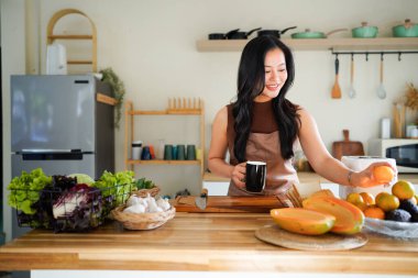 Önlüklü genç bayan kahvaltısını hazırla ve sabah kahvesinin keyfini çıkar, mutfağında..