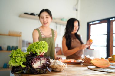 İki arkadaş, neşeli bir salata hazırlıyor. Güneşli bir mutfakta, kahkahalarımızı ve sağlıklı beslenme alışkanlıklarımızı paylaşıyoruz...