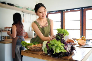 İki arkadaş, neşeli bir salata hazırlıyor. Güneşli bir mutfakta, kahkahalarımızı ve sağlıklı beslenme alışkanlıklarımızı paylaşıyoruz...