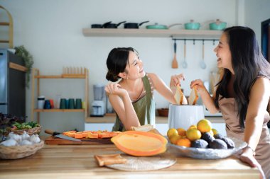 Kahvaltıda kızarmış ekmek yapmak için elektrikli tost makinesi kullanan iki genç kadın. Kızarmış ekmek yapmak için elektrikli tost makinesi kullanan iki kadın ve lezzetli bir kahvaltı..