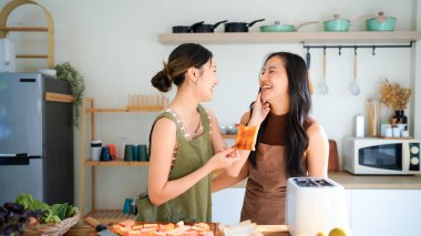 Kahvaltıda kızarmış ekmek yapmak için elektrikli tost makinesi kullanan iki genç kadın. Kızarmış ekmek yapmak için elektrikli tost makinesi kullanan iki kadın ve lezzetli bir kahvaltı..