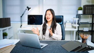 Modern ofisteki iş yerinde dizüstü bilgisayarla çalışan kendine güvenen bir iş kadını..