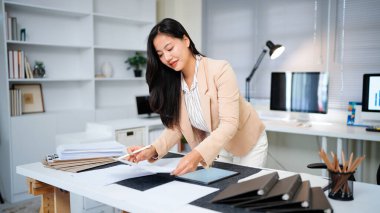 Belgeyi inceleyen kadın modern ofis masasında duruyor..