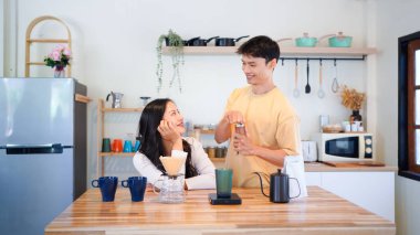Yapılacak birkaç Asyalı, kahve öğütücüsüyle romantik anlar, sabah kahve fincanı ve mutfak eşyaları için kavrulmuş kahve çekirdekleri. Yaşam tarzı kavramı.