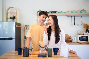 Birkaç Asyalı ya da bir çift kahve çekirdeği koklayacak, mutfakta kahve yapacak ya da demleyecek. Bardak, kupa, şişe ve mutfak malzemelerini de masaya koyun. Sabah yaşam tarzı kavramı, aşk, mutluluk, aile, ilişki..