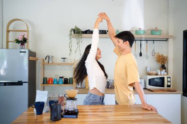 Mutlu çift, evde aşk, aşk ya da tatil için mutfakta dans ve eğlence kaynaşması. Asyalı erkek ve kadın romantik bir ilişki için mutlulukla dans ediyor ya da evde hafta sonunun keyfini çıkarıyor..
