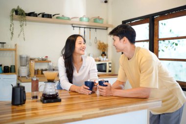 Mutlu, aşık ve gülerken Asyalı bir çift bir ilişkide iyi iletişim kurarken sabah kahvesinin ve muhabbetinin tadını çıkarıyor. Karı koca mutfakta konuşurken konuşuyor..
