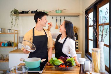 Aşk, yemek ve aşçılık mutfakta bir çiftle kahvaltı, sabah ve mutluluk için. Gülümse, dikkat et ve beslen. Mutlu olmak için evde yemek yiyen erkek ve kadınla..