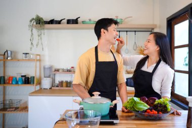 Aşk, yemek ve aşçılık mutfakta bir çiftle kahvaltı, sabah ve mutluluk için. Gülümse, dikkat et ve beslen. Mutlu olmak için evde yemek yiyen erkek ve kadınla..