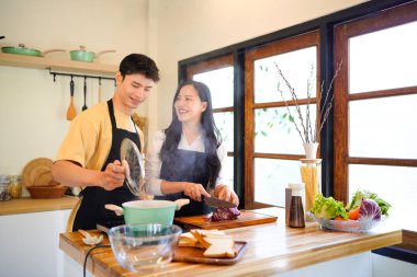 Aşk, yemek ve aşçılık mutfakta bir çiftle kahvaltı, sabah ve mutluluk için. Gülümse, dikkat et ve beslen. Mutlu olmak için evde yemek yiyen erkek ve kadınla..