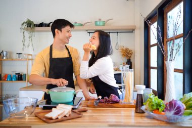 Aşk, yemek ve aşçılık mutfakta bir çiftle kahvaltı, sabah ve mutluluk için. Gülümse, dikkat et ve beslen. Mutlu olmak için evde yemek yiyen erkek ve kadınla..