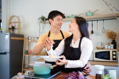 Yatay mutlu çift sıcacık bir ev mutfağında makarna pişiriyor sıcak ışık, tencere ve doğal renklerden yükselen buhar neşeli ve samimi bir atmosfer yaratıyor, yaşam tarzı için ideal..