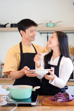 Yatay mutlu çift sıcacık bir ev mutfağında makarna pişiriyor sıcak ışık, tencere ve doğal renklerden yükselen buhar neşeli ve samimi bir atmosfer yaratıyor, yaşam tarzı için ideal..