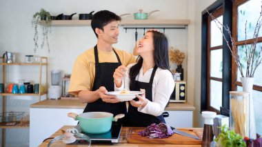 Yatay mutlu çift sıcacık bir ev mutfağında makarna pişiriyor sıcak ışık, tencere ve doğal renklerden yükselen buhar neşeli ve samimi bir atmosfer yaratıyor, yaşam tarzı için ideal..
