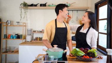 Aşk, yemek ve aşçılık mutfakta bir çiftle kahvaltı, sabah ve mutluluk için. Gülümse, dikkat et ve beslen. Mutlu olmak için evde yemek yiyen erkek ve kadınla..