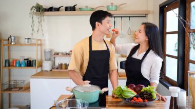 Aşk, yemek ve aşçılık mutfakta bir çiftle kahvaltı, sabah ve mutluluk için. Gülümse, dikkat et ve beslen. Mutlu olmak için evde yemek yiyen erkek ve kadınla..