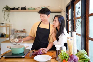Yatay mutlu çift sıcacık bir ev mutfağında makarna pişiriyor sıcak ışık, tencere ve doğal renklerden yükselen buhar neşeli ve samimi bir atmosfer yaratıyor, yaşam tarzı için ideal..