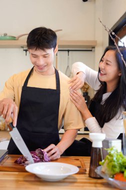 Yatay mutlu çift sıcacık bir ev mutfağında makarna pişiriyor sıcak ışık, tencere ve doğal renklerden yükselen buhar neşeli ve samimi bir atmosfer yaratıyor, yaşam tarzı için ideal..