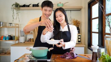 Yatay mutlu çift sıcacık bir ev mutfağında makarna pişiriyor sıcak ışık, tencere ve doğal renklerden yükselen buhar neşeli ve samimi bir atmosfer yaratıyor, yaşam tarzı için ideal..