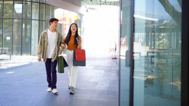 Güzel bir çift alışverişi sever, alışveriş torbası tutan genç bir çift, alışveriş yapan bir çift, bir çift, bir çift, alışveriş torbası taşıyan bir erkek ve bir kadın sokakta yürürken sarılıp gülümsüyor..