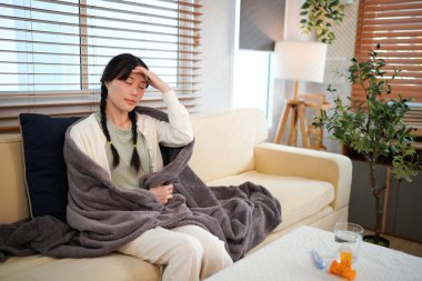 Hasta, virüs enfeksiyonu, grip ya da oturma odasındaki kanepede alerji olan bir kadın. Kız, kış ve ateş, dinlenme odasında yüksek ateş, battaniyeli soğuk ya da sağlık sorunu.