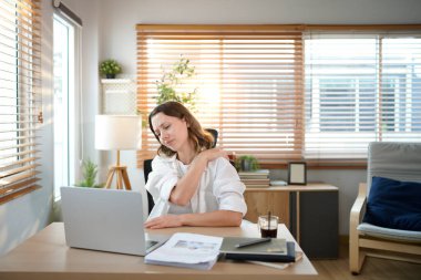 Kadın girişimci acı çeken omuz ağrısı çekiyor. Masaj yaparken omzuna vuruyor..