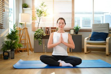 Genç sporcu kadın evde yoga yapıyor. Sağlıklı bir yaşam tarzı. Spor sağlık insanları yaşam tarzı konsepti.