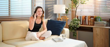 Telefon görüşmesi ve beyaz kadın kanepede, sohbet ya da evdeki iletişim. Akıllı telefon, konuşma ve beyaz adam gülüyor, hikaye ve komedi dinliyor, sohbet veya haber dinliyor ve oturma odasında mutlu..