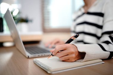 Ofis masasında dizüstü bilgisayarı olan bir kalem ile kadın elinin fotoğrafını çek. İş kadını plan yapıyor, hatırlatma yapıyor. Öğrenci çevrimiçi, e-öğrenim.