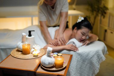 Aromaterapi masajı ambiyansı ya da spa salonu kompozisyon düzeneği, odak dekor mumları ve spa aksesuarları ve tatil köyü veya otel arka planında keyifli aroma masajı yapan bulanık kadın..